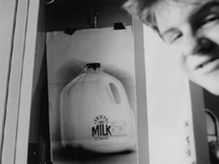 “Ballad”: the boy’s face beside a pinned-up photograph of a gallon of milk, from the AICP Show archive