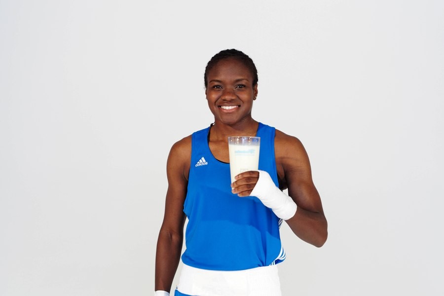 Nicola Adams in a blue boxing vest holding a glass of milk